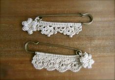 two crocheted hooks are sitting on a wooden surface with one hook in the shape of a flower