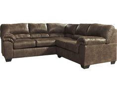 a brown leather sectional couch sitting on top of a white floor