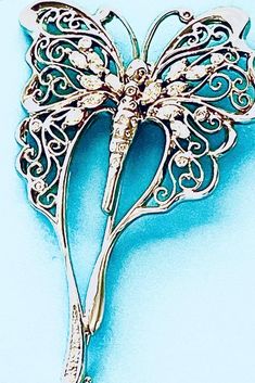 The brooch is worked in intricate, lacy gold filigree of delicate twisting tendrils. It is framed in a wavelike contour of gold. The body (thorax) is highlighted with 6 marquis shaped pale yellow diamonds giving a spectral glow. Round diamonds for the antennae and tail. The pin stem has a clasp closure that locks the pin end in place. Art Nouveau Marquis Diamond  18K White Gold Filigree Brooch Fanciful Luna Moth Woodland Sprite Fae Creature Dragonfly  Description:          18K white gold stamped          6 marquis diamonds total weight 0.74 carats, I color          18 round diamonds total weight .024 carats, H color           length 2 1/2 inches          width 1 1/2 inches  Total weight of this brooch is 17.4 grams. Woodland Sprite, Moth Brooch, Marquis Diamond, Butterfly Dragonfly, Yellow Diamonds, Luna Moth, Gold Filigree, Marquise Diamond, Yellow Diamond