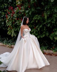 a woman in a wedding dress is walking down the street