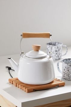 a white tea kettle sitting on top of a table