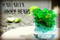 a glass filled with green gummy bears on top of a table