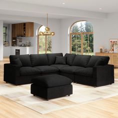 a large black sectional couch sitting on top of a hard wood floor