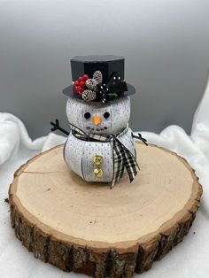 a snowman sitting on top of a tree stump