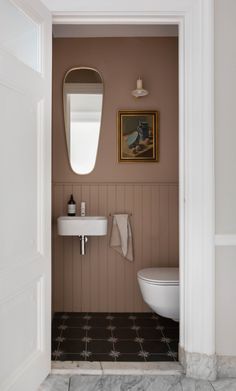 an open door leading to a bathroom with a sink and mirror on the wall next to a toilet