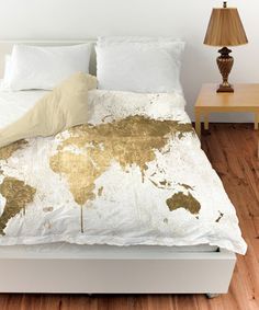 a bed with gold paint on it and white sheets in front of the headboard