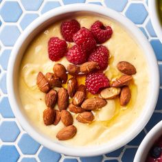 a bowl of oatmeal with raspberries and almonds on top