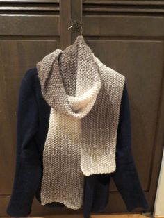 a sweater and scarf hanging on a hook