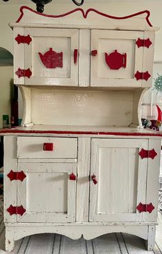 an old white cabinet with red paint on it