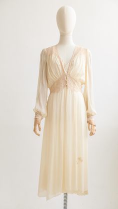 Date: 1930 Description: Exquisite silk chiffon boudoir dress in a delicate shade of ivory. She boasts lace panels at the shoulders, waistline and cuffs. With her empire waistline and delicate bishop sleeves, this is a beautiful and rare piece indeed. With plenty of versatility, I photographed her with a silk slip underneath but please be aware that this garment is sheer.  Measurements:  Best Fits Size Medium // UK 10 // US 6 Shoulders: 14" Sleeves: 25" Bust: 19" Waist: 28" Hips: free Length: 47" Transparent Sleeves Dress, Digital Closet, Empire Waistline, Ivory Silk, Silk Slip, Lace Panelled, Silk Chiffon, Dress Clothes For Women, Empire Waist