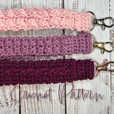 three crocheted key fobs on a white wooden background with the words crochet patron written below them