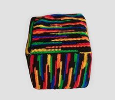 multicolored crocheted box sitting on top of a white surface