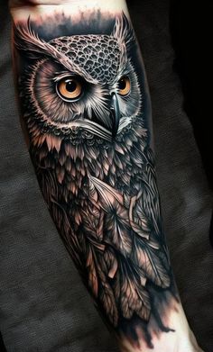 an owl tattoo on the arm with orange eyes and black ink, is shown in this image