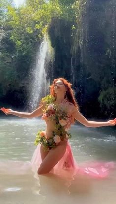 a woman in a pink dress standing in the water