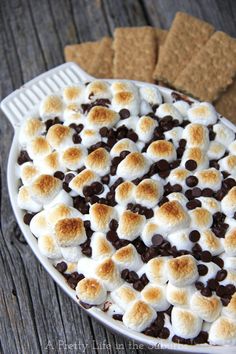 a pie with marshmallows and chocolate chips on top sitting on a table