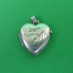 Description : A pretty vintage sterling silver heart shaped locket with engraved decoration. Marks : Marked Silver to the back. Weight : It weighs 1.8 grams. Size : 1.7cm long, 1.5cm wide. Condition : In very good condition. FREE UK POSTAGE. Formal Engraved Heart Pendant Locket Necklace, Classic Engraved Heart Locket Necklace, Engraved Double Heart Locket Necklace In White Gold, Antique Heart Locket Necklace For Formal Occasions, Classic Engraved Heart Shaped Locket Necklace, Silver Heart Pendant Locket Necklace With Vintage Charm, Antique Silver Locket Necklace For Valentine's Day, Vintage Double Heart Engraved Locket Necklace, Silver Heart Pendant Locket Necklace With Hallmark