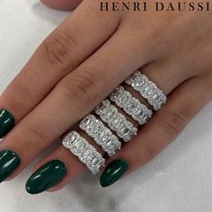 a woman's hand with green fingernails and five diamond rings on her fingers, all in white gold