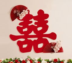 red paper cut out with flowers and fan on table