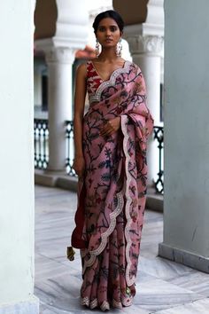 Rosewood pink saree with intricate hand painted kalamkari floral patterns, signature thread and mirror work border. Paired with silk embroidered bralette blouse.
Component: 2
Pattern: Hand Painted, Embroidered
Type Of Work: Kalamkari, Floral Patterns
Neckline: V-Neck
Sleeve Type: Sleeveless
Fabric: Silk
Color: Pink
Other Details: 
Embroidered scalloped hem saree
Embroidered blouse
Length: Saree- 5.50 Mtrs
Occasion: Wedding, Bride
Disclaimer: This product will be exclusively handcrafted, making t Archana Jaju Sarees, Archana Jaju, Mirror Work Border, Long Blouse Designs, Fashionable Saree Blouse Designs, Draping Fashion, Sari Blouse Designs, Kalamkari Saree, Saree Designs Party Wear