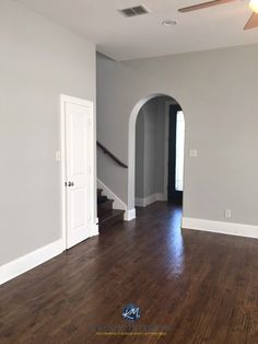 an empty living room with hard wood flooring and white trim on the door way