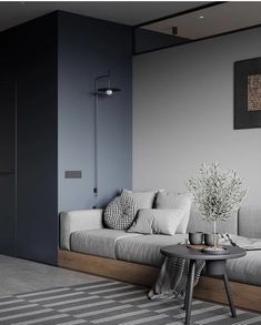 a living room with grey walls and white couches in the corner, along with a coffee table