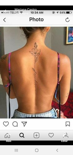 the back of a woman's neck with a flower tattoo on her left side