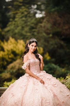 a woman in a ball gown sitting on a bench with her hand on her hip