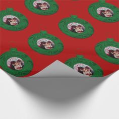 a red wrapping paper with an image of two people in green frames on the side