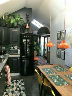 a kitchen with black cabinets and an orange light hanging from the ceiling over the counter