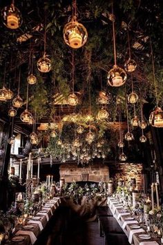 the dining room is decorated with hanging lights and greenery for an elegant touch to the space