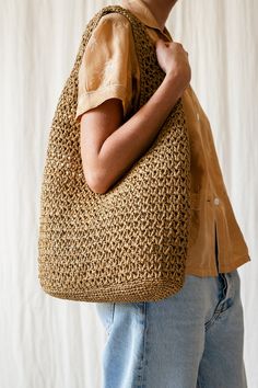 a woman carrying a large woven bag on top of her back, in front of a white background