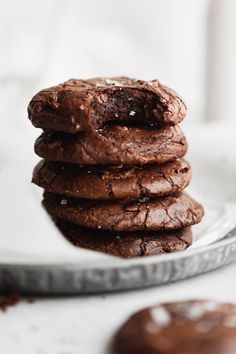 a stack of chocolate cookies sitting on top of a white plate