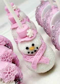 there are some frosted donuts with pink icing on them and one has a snowman