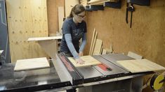 a woman cutting wood with a table saw