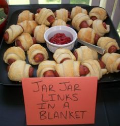 a tray filled with hot dogs and ketchup next to a sign that says jar jar links in a blanket