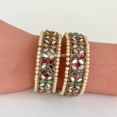 Navratan Mirror Pearl Bangles Set(2 Pc)/Pearl bangles/Stones bangles/Indian bangles/Punjabi Pearl bangles Set/Bridal bangles/wedding jewelry Sold as a pair This is 100% Handmade jewelry. So Color, shades, and texture displayed may slightly vary from the actual product due to digital image limitations. We request you to consider these minor variations. Please expect the possibility of some slight imperfections when buying handmade jewelry. If you have any questions, please message or email us. Arrives in a gift box. Please let me know if you have any questions. Thank you so much for visiting my shop. Jeweled Bangle For Wedding And Diwali, Multicolor Temple Jewelry Bangle For Wedding, Multicolor Bollywood Bangle For Weddings, Multicolor Cutdana Bangle, Bollywood Style Multicolor Wedding Bangle, Multicolor Round Wedding Bangle, White Bangle With Stone Work For Diwali, Multicolor Stone Work Bangle For Wedding, Jeweled Multicolor Bangle For Festivals