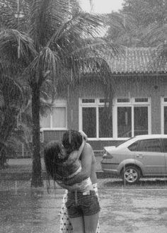 two people hugging each other in the rain