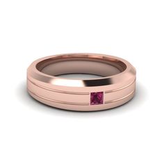 a rose gold wedding band with a pink sapphire stone in the center