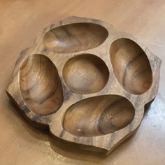 four wooden bowls sitting on top of a table