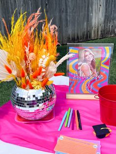 there is a disco ball with flowers in it on the table next to some books