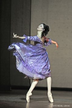 a woman in a purple dress is dancing