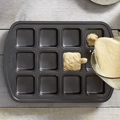 a person pouring batter into a muffin pan