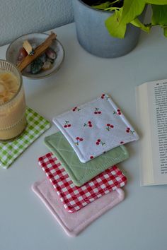 three napkins on a table next to a glass of milk and an open book