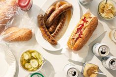 a table topped with lots of food next to sodas and glasses filled with drinks