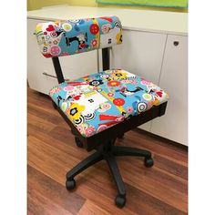 a colorful office chair with wheels in front of a white cabinet and wooden flooring