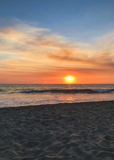 the sun is setting over the ocean with waves