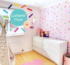 a child's room decorated in pink, white and blue with colorful sprinkles