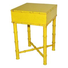 a yellow side table with two legs and a drawer on the top that is made out of bamboo