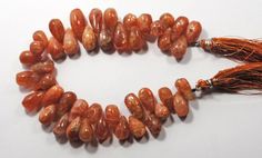 an orange beaded necklace with tassels and beads