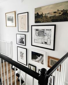 a staircase with pictures on the wall and photos hanging up against the bannister